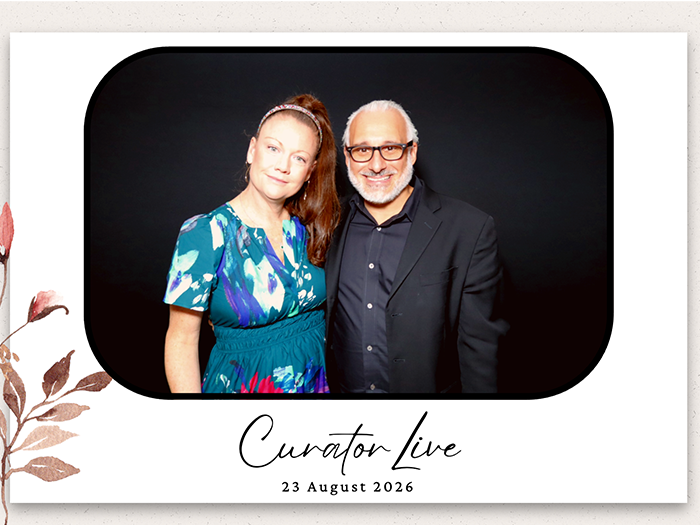 A finished single-photo print from a Curator booth: a couple against a black backdrop inside a white template with a script wordmark and the event date.