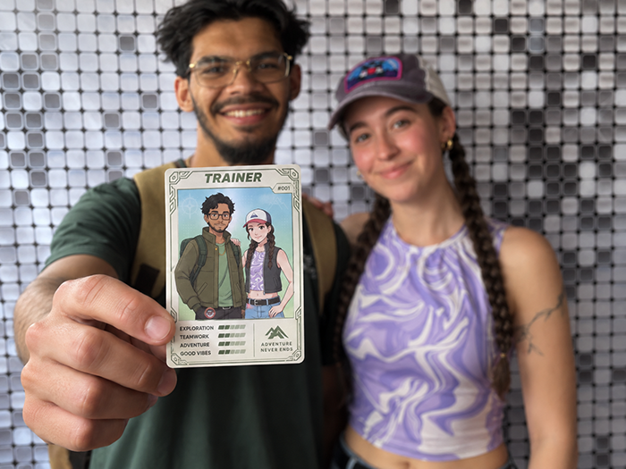 Two guests holding a trading card printed at their event, moments after it came off the booth&rsquo;s printer.