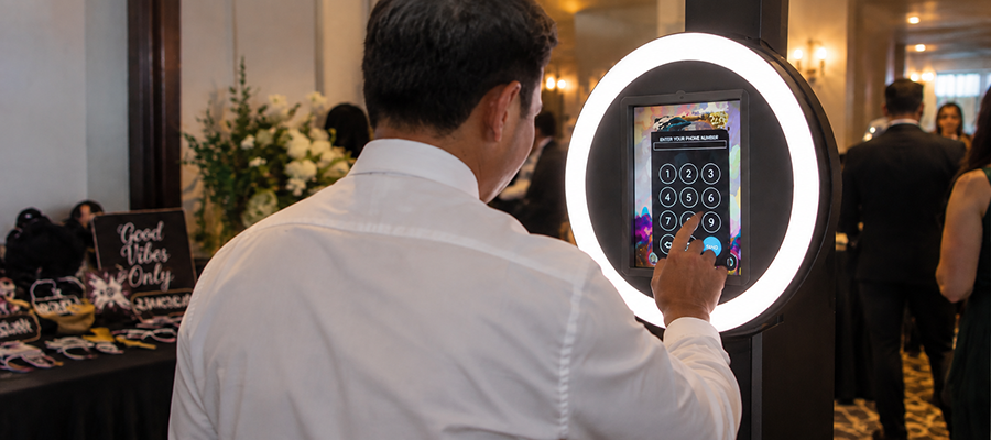 A guest at a Curator ring-light iPad booth sending her photo to her phone.